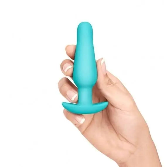 Person holding a blue silicone toy from b-Vibe Anal Training Kit and Education Set