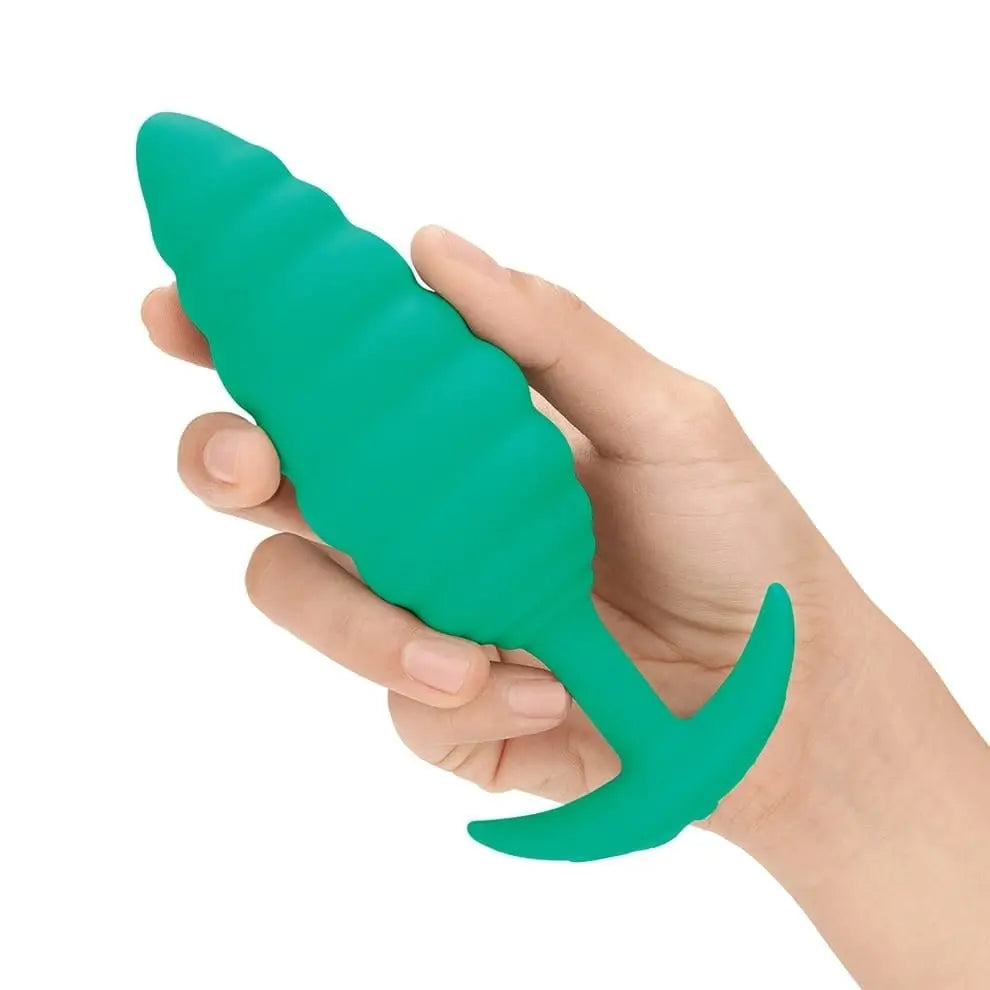 Hand holding b-Vibe Large Texture Plug in green, showcasing the texture plug design