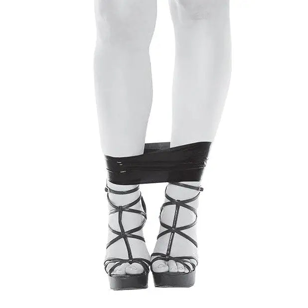 A woman in white tights and black stockings restrained with Evolved PVC Bondage Tape