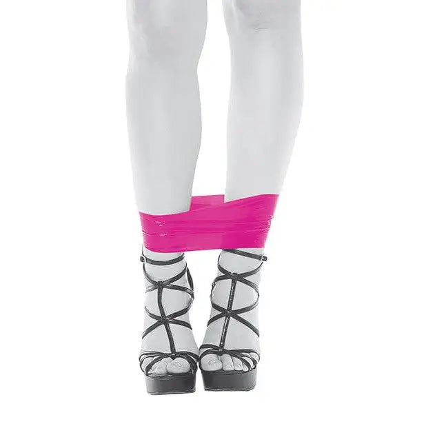 Woman in knee braces using Evolved PVC Bondage Tape for secure and stylish restraint