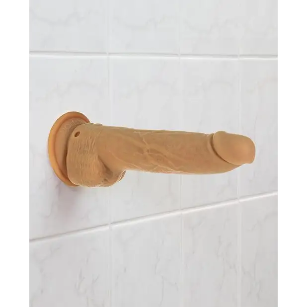 A person holding a Naked Addiction 9” Thrusting Dildo made of platinum cured silicone