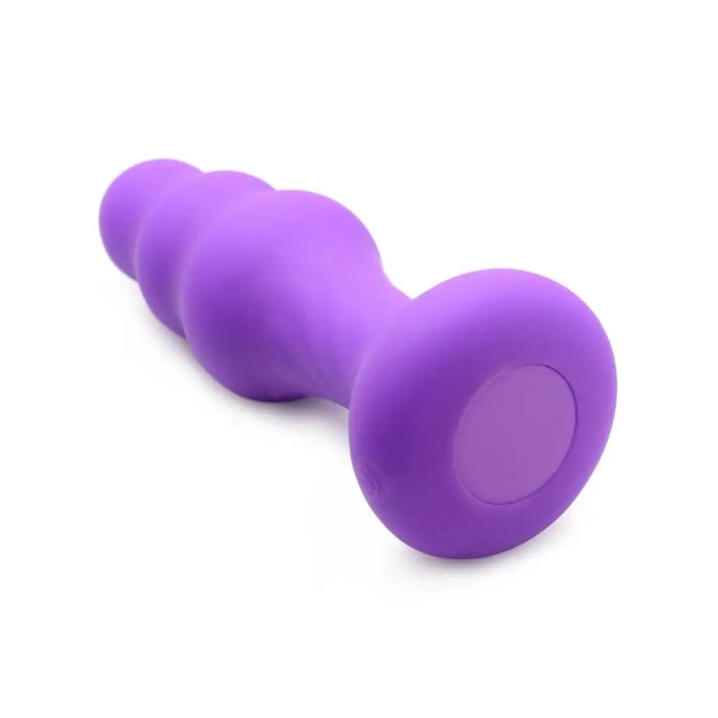 Purple silicone anal plug with a slim ribbed thumping curved, bulbous shape