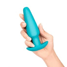 Hand holding a blue toy from the b-Vibe 7-Piece Anal Training Kit and Education Set