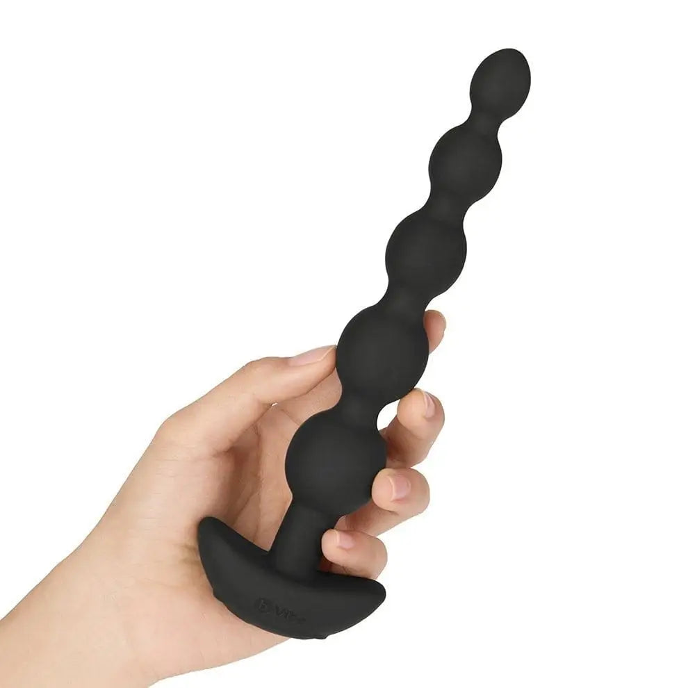 Hand holding b-Vibe Cinco vibrating silicone anal beads