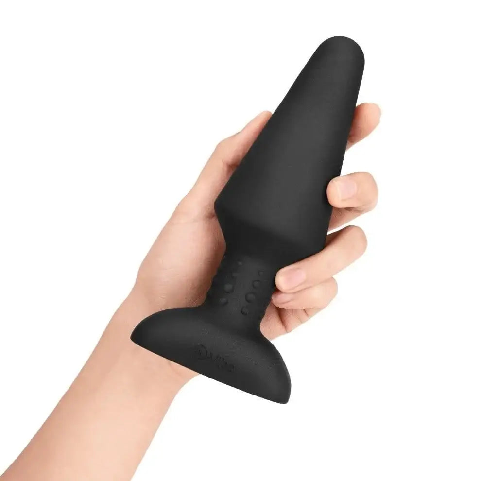 A person holding the b-Vibe Rimming Plug XL, a premium vibe rimming plug with wireless remote