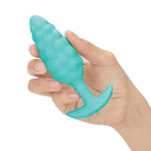 A hand holds a green b-Vibe Small Texture Plug with bump texture for enhanced sensation