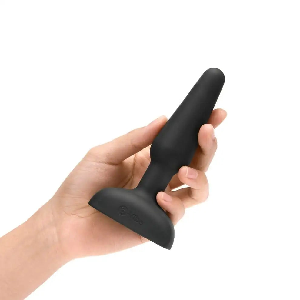 b-Vibe Trio Plug with three motors in black silicone case held in hand