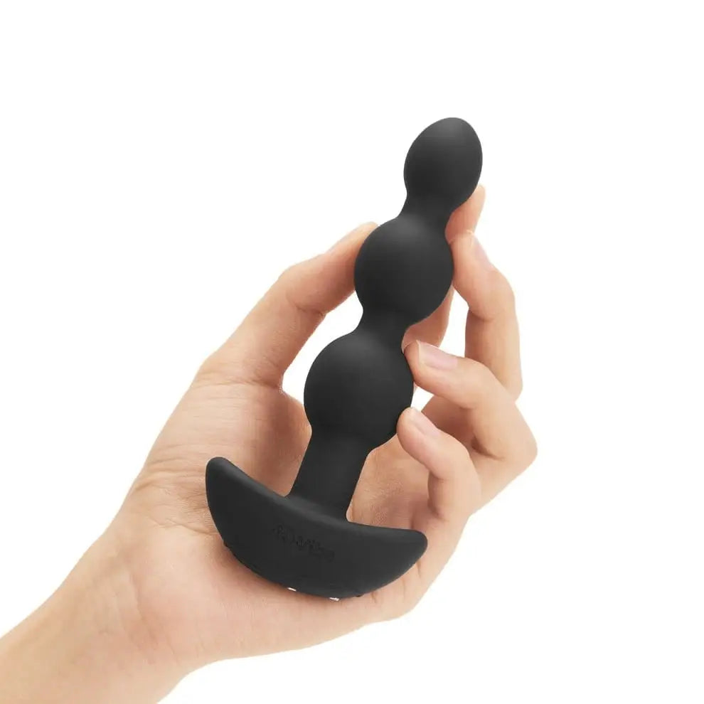 Hand holding b-Vibe Triplet Anal Beads, highlighting color and features