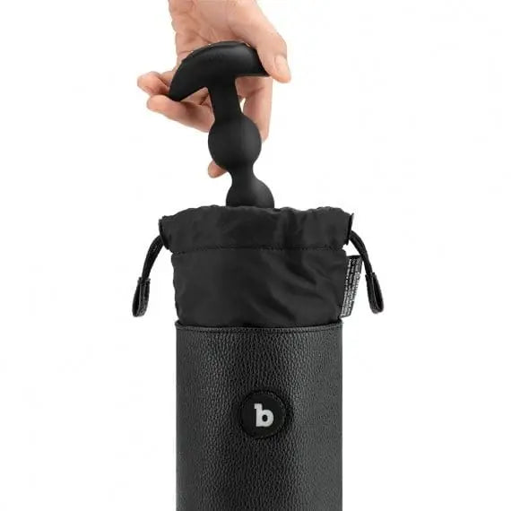 Hand holding a black leather wine bottle holder from b-Vibe UV Sterilizer Pouch for sex toys