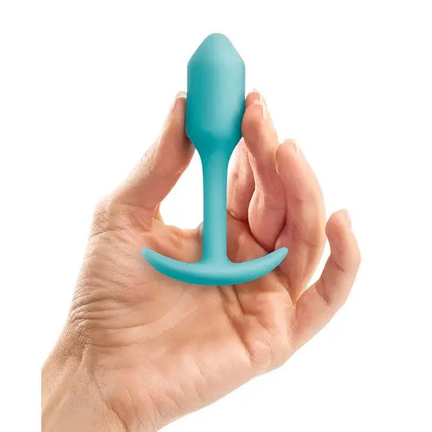 A hand holding the b-Vibe Weighted Snug Plug 1 with a smooth grip handle