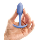 Hand holding a blue b-Vibe Weighted Snug Plug 1 with a smooth grip handle