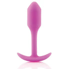 Pink silicone b-Vibe Weighted Snug Plug 1 with smooth grip handle and long tail, 55 grams