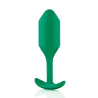 Green plastic spoon handle with b-Vibe Weighted Snug Plug 2 - 114 Grams