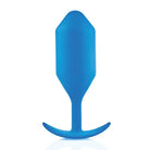 A blue plastic spoon with a curved handle for the b-Vibe Weighted Snug Plug 5 - 350 Grams