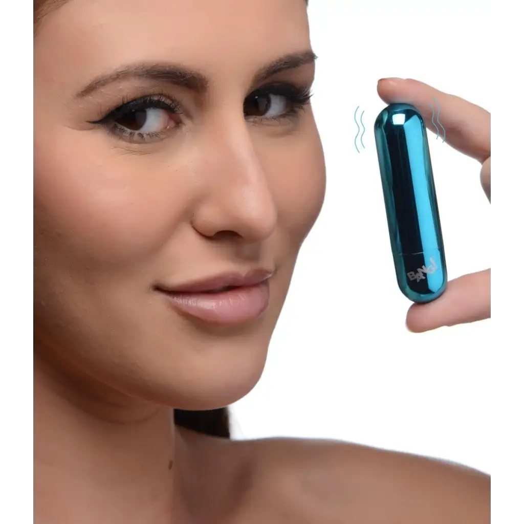 Woman holding BANG! 10x rechargeable vibrating metallic bullet near her face