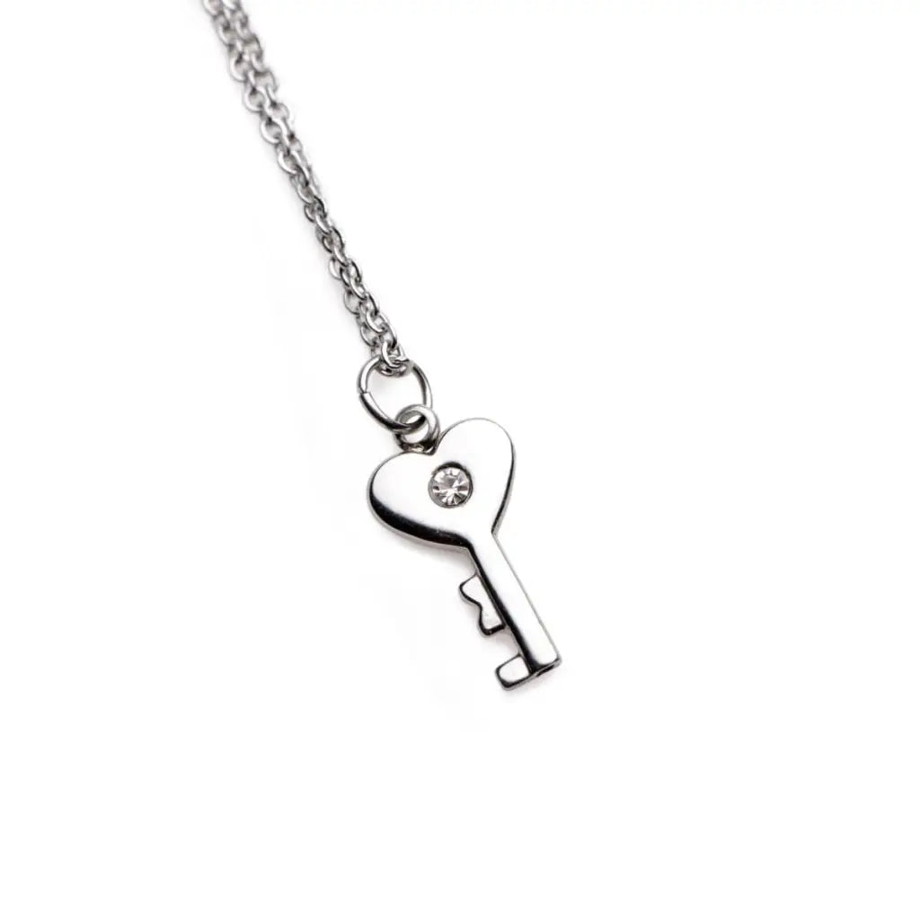 Silver key-shaped pendant on chain necklace with heart bow and gemstone from Chained Locking Bracelet