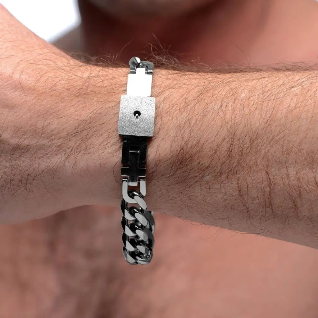 Hairy wrist wearing a chained locking bracelet with chain link design and square clasp