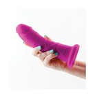 Hand holding Colours Dual Density toy in purple, showcasing the 7 in. Dildo product