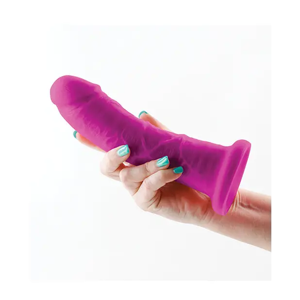 Hand holding Colours Dual Density toy in purple, showcasing the 7 in. Dildo product