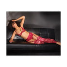 Woman in red scallop stretch lace bra, garter belt & thong on black leather couch