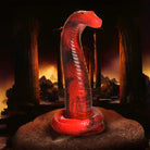 A red snake on a rock in front of a fireplace with the Creature Cocks King Cobra Silicone Dildo