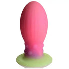 Pink silicone Creature Cocks Xeno Egg with a green base, glowing in the dark