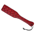 Crimson Tied Steel Enforced red leather paddle with geometric flower pattern and wrist strap