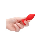 Hand holding Diamond Heart Butt Plug, a sleek red plastic heart butt plug for intimate use