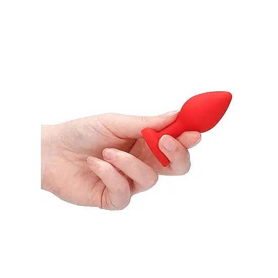 Hand holding Diamond Heart Butt Plug, a sleek red plastic heart butt plug for intimate use