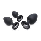 Black ear plugs with ’u’ from the Dirty Words Anal Plug Set