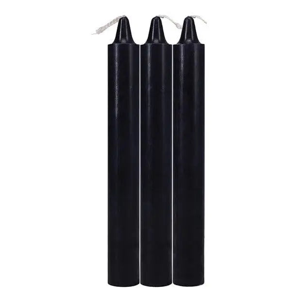 Three tall, black Doc Johnson Japanese drip candles with visible wicks