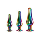 The Evolved Rainbow Metal Plug Set displayed with three colorful glass candles on a white backdrop