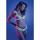 Woman posing in Fantasy Lingerie Glow Night Vision white and green lingerie, blue-lit background