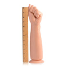 A hand holding a ruler next to the Fisto Clenched Fist Dildo for size comparison