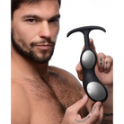 Black and silver premium silicone weighted prostate plug with T-shaped handle in hand