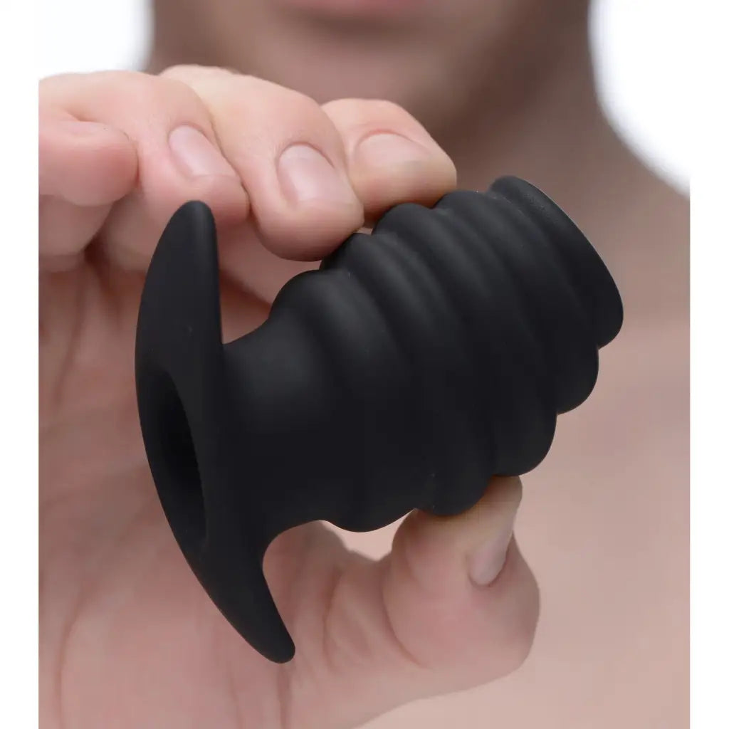 A man holding a black rubber ball for Hive Ass Tunnel Silicone Ribbed Hollow Anal Plug