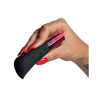 A woman’s hand holding a black and pink nail brush next to the Hot Octopuss AMO Bullet Vibrator