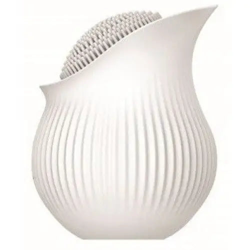 inBloom Lilium flower-shaped massaging vibrator in a white ceramic vase with ribbed texture