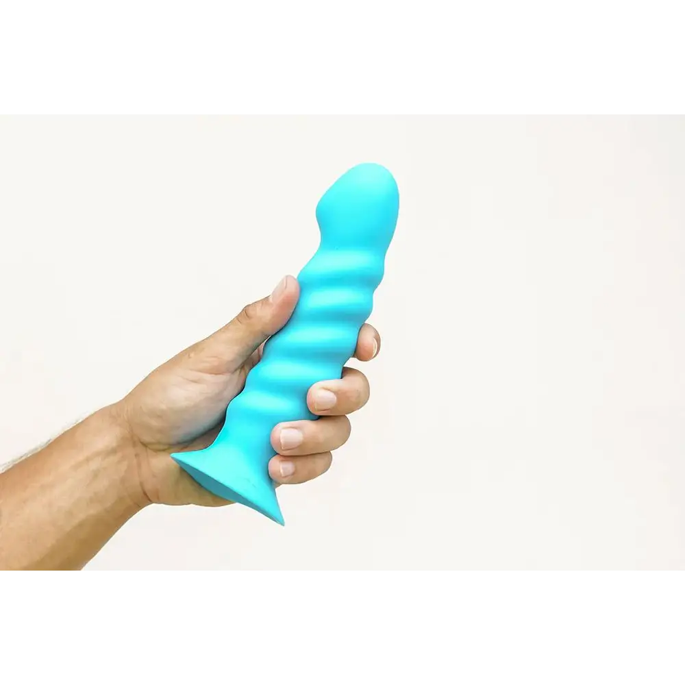 Hand holding Kendall Silicone Dong, a blue medical-grade silicone toy from Maia Toys