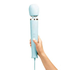 Hand holding Le Wand Powerful Plug-in Vibrating Massager in pale blue