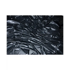 Crumpled black Lux Fetish Vinyl Bed Sheet with reflective creases and folds