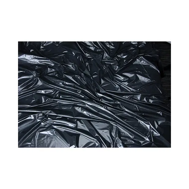 Crumpled black Lux Fetish Vinyl Bed Sheet with reflective creases and folds