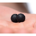 Orbs Nubbed Silicone Magnetic Balls: Two small black spheres with textured surfaces on a palm