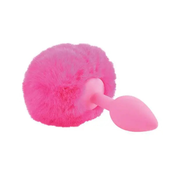 Close up of Neon Luv Touch Bunny Tail Silicone Butt Plug with pink furry toy and dill