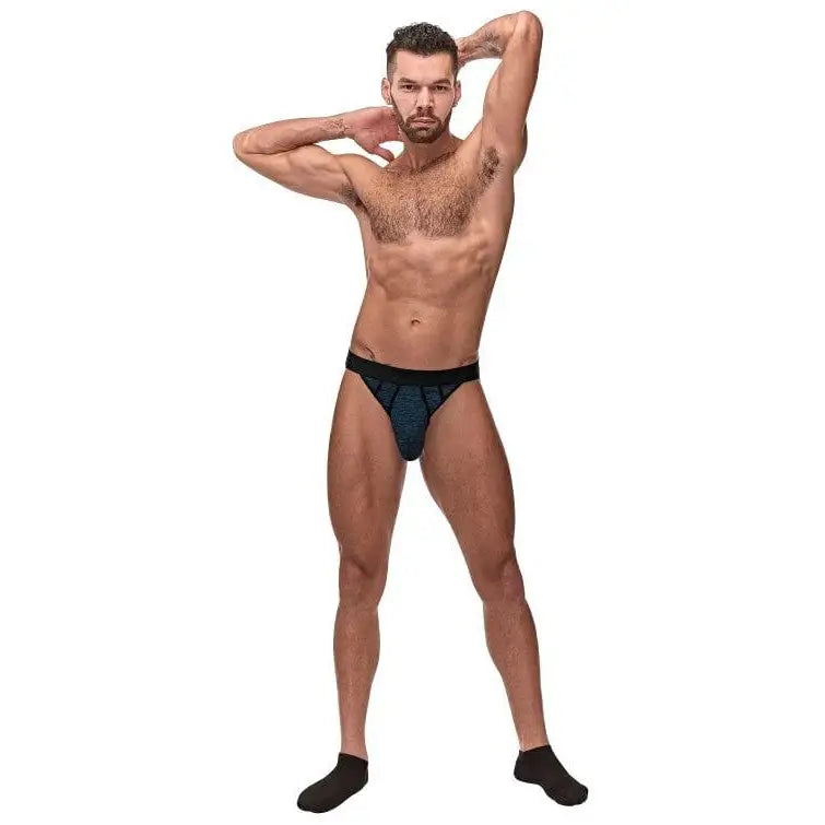 Muscular man in Peak Performance Sport Jock, posing in underwear and socks, white background