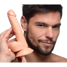 Person holding Pop Peckers 6.5’ Dildo with Balls featuring a suction cup base near their face