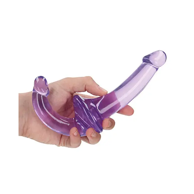 Hand holding RealRock Crystal Clear 6 in. Strapless Strap-On Dildo in purple