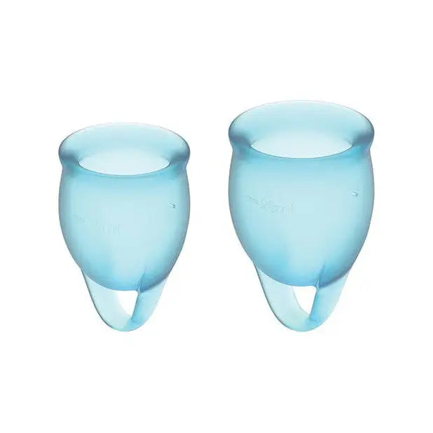 A pair of blue glass vases next to Satisfyer Feel Confident menstrual cup for stylish periods