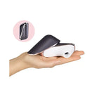 Person holding Satisfyer Pro Traveler Rechargeable device against pink background