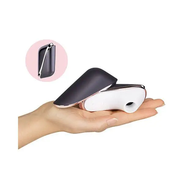 Person holding Satisfyer Pro Traveler Rechargeable device against pink background